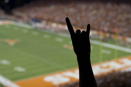 A fan makes the Hook 'em Horns gestures