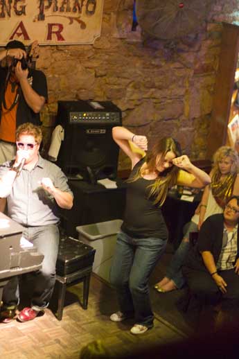 A woman dances beside a piano player